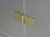 A close-up shot of a gold hinge on a glass shower door. Produktbild-Vorschau