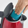 A hand is cleaning the inside of a red electric kettle with a blue sponge. Anteprima dell’immagine prodotto