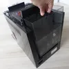 A hand is shown removing a transparent plastic water tank from a black coffee machine. Produktbild-Vorschau