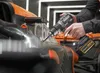 A person is using a DeWalt drill on a race car. Voir les images du produit