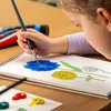 A child is painting flowers in a sketchbook. Produktbild-Vorschau