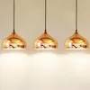 Three copper pendant lights hanging against a plain wall. Produktbild-Vorschau
