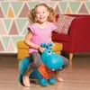 A young girl is happily riding a blue inflatable hippo toy in a living room setting. Anteprima dell’immagine prodotto