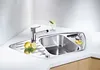 A stainless steel corner sink with a faucet, lemons, and mint leaves on a white countertop. Náhled obrázku produktu