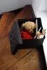 A storage ottoman filled with stuffed animals sits on a wooden staircase. Náhľad obrázku produktu