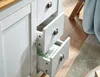 A close-up view of a white sideboard with three drawers, one of which is partially open, revealing a green and white polka dot patterned liner. The sideboard has silver handles and is set against a wooden floor and a rug. Podgląd zdjęcia produktu