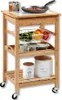 A kitchen cart with various items on it, including a frying pan, vegetables, mugs, and canisters. Produktbild-Vorschau