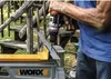 A person is using a cordless drill to drill into a metal piece that is clamped to a workbench. Produktbild-Vorschau