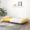 A yellow sofa bed with white bedding and a pillow is shown in a room with a plant and a coffee table. Náhľad obrázku produktu