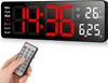 A hand holding a remote control in front of a digital clock. Produktbild-Vorschau