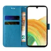 A blue flip phone case with floral and butterfly embossing, showing a phone inserted, with credit cards and a banknote in the slots. Produktbild-Vorschau