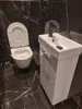 A modern bathroom with a toilet and a small sink vanity. Podgląd zdjęcia produktu