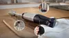 An immersion blender is shown on a wooden cutting board with a white cloth. Produktbild-Vorschau