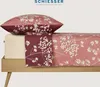 A bed with a pillow and duvet cover, showcasing a floral pattern. Produktbild-Vorschau