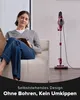 A woman sits on a couch reading a book while a vacuum cleaner stands upright behind her. The image has a superimposed text overlay at the bottom. Produktbild-Vorschau