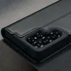 A close-up shot of a black leather phone case, showing the camera cutout and the textured leather. Produktbild-Vorschau