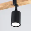 A black cylinder spotlight is attached to a wooden beam. Podgląd zdjęcia produktu