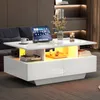 A modern living room setting with a white coffee table featuring LED lighting, a tablet, a cup of coffee, books, and decorative items. Produktbild-Vorschau