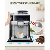 A coffee machine is shown on a kitchen counter, with a hand pushing it to demonstrate ease of movement. There are also coffee beans and a cup of coffee. Produktbild-Vorschau