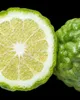 A close-up view of a halved bergamot fruit and a whole bergamot fruit against a black background. Produktbild-Vorschau