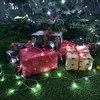 Christmas presents wrapped in festive paper under a Christmas tree with fairy lights. Anteprima dell’immagine prodotto