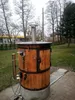 An outdoor setting with trees and grass, featuring a wooden electric smoking chamber. Náhled obrázku produktu