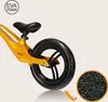 Close-up of the rear wheel and frame of a yellow balance bike, with a magnified view of the EVA foam material. Produktbild-Vorschau