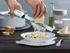 Hands grating cheese over a bowl of food. Anteprima dell’immagine prodotto