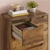 A close-up view of a wooden dresser with one drawer pulled out, revealing a book inside. Podgląd zdjęcia produktu
