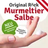 A hand holding a dollop of cream, with marketing text and graphics around it. Produktbild-Vorschau