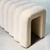 A close-up view of a beige upholstered bench with a ribbed design. Produktbild-Vorschau