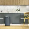 A modern kitchen with gray cabinets, a marble backsplash, and a wooden countertop. A gray trash can is placed on the wooden floor next to a yellow chair. Anteprima dell’immagine prodotto
