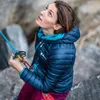 Frau mit blauer Jacke und rosa Hose; schaut nach oben; während sie ein Sicherungsgerät von Rama hält. Produktbild-Vorschau