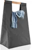 A dark grey laundry bag with a light blue shirt draped over the handle. Produktbild-Vorschau