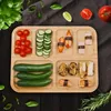 A bamboo serving tray filled with various food items like cherry tomatoes, sliced cucumbers, zucchini, and sushi. Produktbild-Vorschau