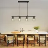 A dining room with a chandelier hanging over a table and chairs. Anteprima dell’immagine prodotto