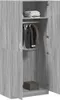 Interior view of a gray wood-grain wardrobe with two doors open, showing clothes hanging on a rod and a box on the bottom shelf. Produktbild-Vorschau