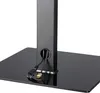 Close-up of the base of a black TV stand with cables routed through a hole in the vertical support. Produktbild-Vorschau