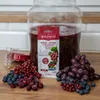 A product packaging for yeast and nutrient for red wine, alongside fresh grapes, red currants, and blueberries. Produktbild-Vorschau