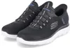 A pair of black Skechers slip-on sneakers with white soles, shown from a slightly elevated side angle against a white background. Náhled obrázku produktu