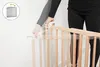A person is shown installing a wooden baby gate. Produktbild-Vorschau
