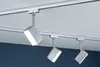 Three track lights are mounted on a white track attached to a white ceiling. The background below the track lights is a dark blue wall. Anteprima dell’immagine prodotto