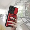 A hand holding a red and black phone case with a ring holder, with a blurred indoor background. Produktbild-Vorschau