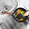 A person is cleaning a dirty frying pan in a kitchen sink. Anteprima dell’immagine prodotto