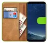 A book-style phone case with a Samsung Galaxy S8 phone inside, showing a card and euro banknotes in the case. Produktbild-Vorschau