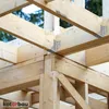 Close-up view of wooden beams being joined together with metal brackets in an outdoor construction setting. Náhled obrázku produktu
