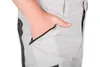 A close-up of a person's hand in the zippered pocket of gray outdoor work pants. Produktbild-Vorschau