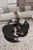 A modern living room scene with a sectional sofa and a unique yin-yang shaped coffee table. Produktbild-Vorschau
