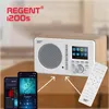 A Regent i200s internet radio is shown on a table, with two smartphones and a remote control. Produktbild-Vorschau