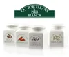 Four white ceramic spice jars with labels and illustrations of spices, arranged in a row on a white background, with a brand logo above. Produktbild-Vorschau
